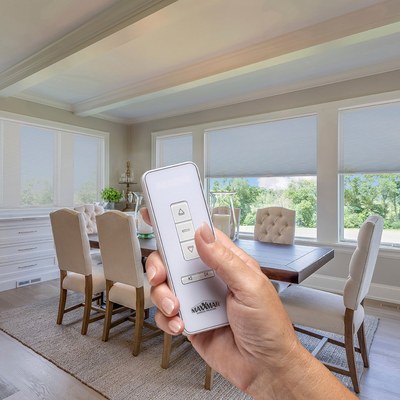 Hand holding a remote control for motorized Cellular Shades