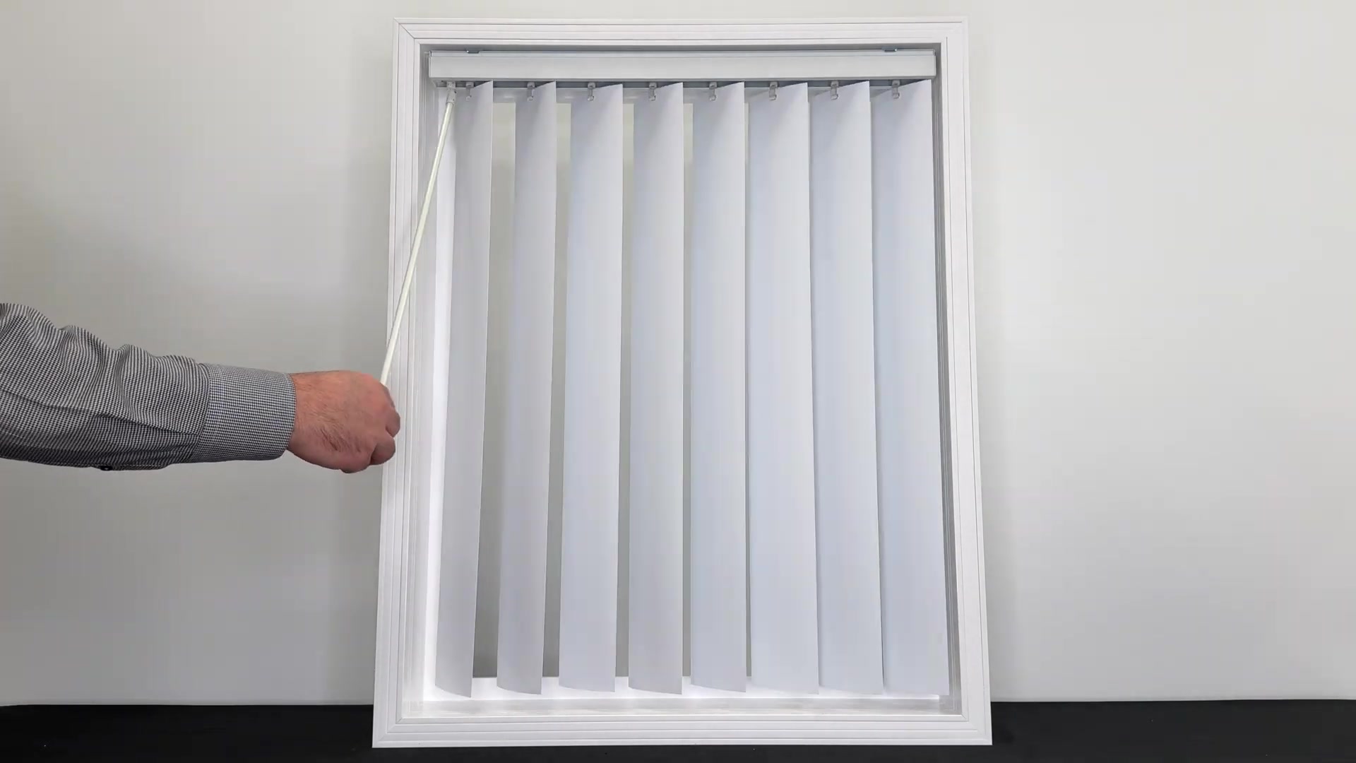 Hand operating a wand control on vertical blinds