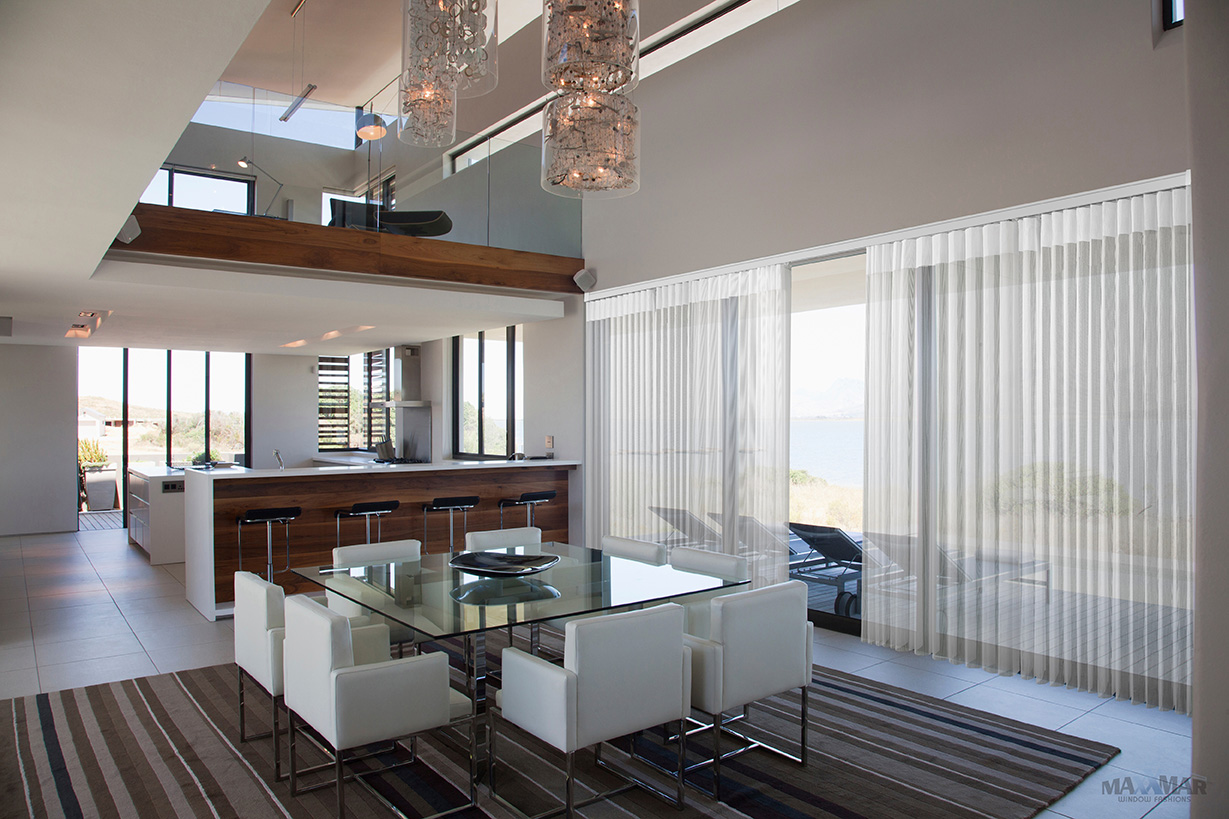 Dream Shades sheer vertical vanes installed at a dining room patio door with ocean view